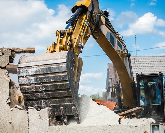 Bulldozer tearing down home